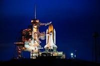 Space shuttle Atlantis, attached to its bright-orange external fuel tank and twin solid rocket boosters on Launch Pad 39A at NASA's Kennedy Space Center in Florida. Original from NASA. Digitally enhanced by rawpixel.