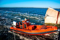 A skiff from Freedom Star, one of NASA's solid rocket booster retrieval ships, helped usher a spent shuttle booster through the shallow waters of the locks at Port Canaveral, Fla. Original from NASA . Digitally enhanced by rawpixel.