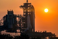Space shuttle Atlantis, attached to its bright-orange external fuel tank and twin solid rocket boosters on Launch Pad 39A at NASA's Kennedy Space Center in Florida. Original from NASA . Digitally enhanced by rawpixel.