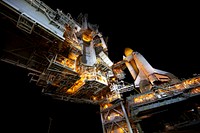 Space shuttle Atlantis, attached to its bright-orange external fuel tank and twin solid rocket boosters on Launch Pad 39A at NASA's Kennedy Space Center in Florida. Original from NASA . Digitally enhanced by rawpixel.