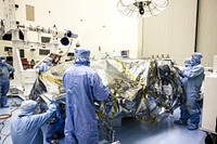 At the Payload Hazardous Servicing Facility at NASA&#39;s Kennedy Space Center in Florida, technicians remove the protective cover from NASA&#39;s Mars Science Laboratory (MSL) rover known as Curiosity, before processing and testing. Original from NASA . Digitally enhanced by rawpixel.