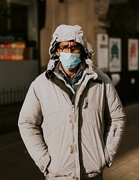 Man wearing a face mask while walking in the city during coronavirus pandemic. BRISTOL, UK, March 30, 2020