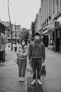 Couple with face masks while shopping in town during coronavirus pandemic. BRISTOL, UK, March 30, 2020