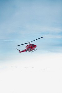 Red helicopter flying in the sky