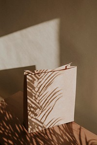 Natural paper bag with palm leaves shadow