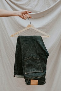 Dark blue jeans on a wooden hanger