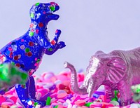 Close up of dinosaurs and animal figure toys on sweet candy sprinkles