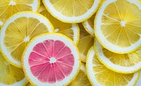 Closeup of slices of lemon and one pink slice standing out textured background