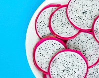 Closeup of a plate of dragon fruit slices on blue background