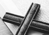 Closeup of wooden cross on bible book religion and belief concept