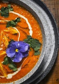 Vegan colorful tomato soup serving on a wooden table