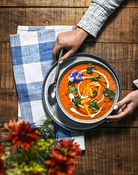 Vegan colorful tomato soup serving on a wooden table