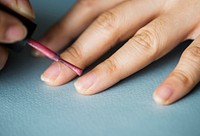 Woman applying nail polish on her nails
