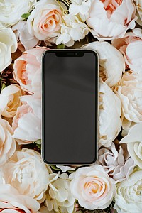 Blank black phone on pastel roses