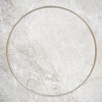 Round gold frame on beige marble background