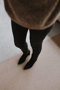 Woman in ankle boots standing in her house