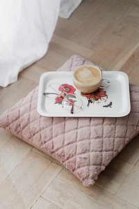 Coffee on a pink velvet cushion on the floor