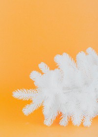 White artificial Christmas tree on yellow background