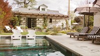 Wooden seats by a pool with parasols