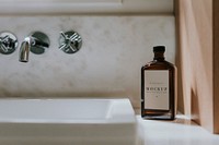 Liquid brown bottle mockup by a basin