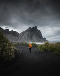 Man walking on a black sand beach, Iceland