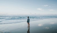 Woman standing on the beach in the morning
