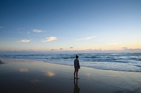 Woman standing on the beach in the morning