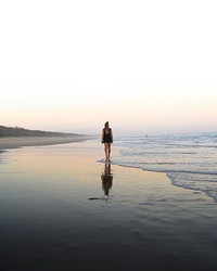 Rear view of woman walking along the beach