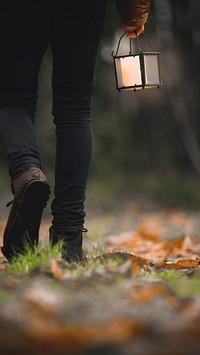 Mobile wallpaper background, man walking with a lantern in a woods