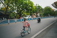 Vietnamese woman riding a bike on a road