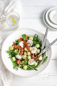 Colorful summer salad bowl with parma ham