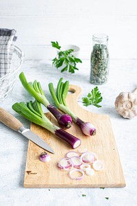 Red spring onions on a wooden cutting board