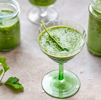 Green smoothie decorated with a spinach leaf  in a glass