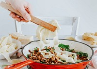 Mixing of homemade pappardelle pasta with mushrooms