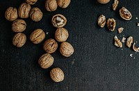 Dried walnuts on a black wooden background