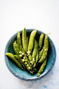 Fresh organic peas in a blue cup