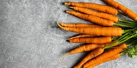 Fresh organic bunch of carrots on a gray kitchen top aerial view
