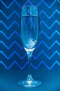 Glass of champagne on zig zga pattern background