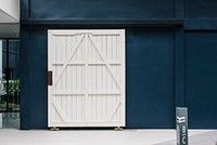 Wooden white door on a blue building wall