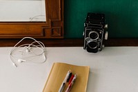 Old camera, earphones and a notebook
