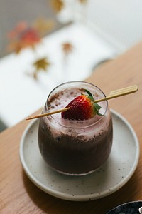 Iced chocolate serve with fresh strawberry in a skewer