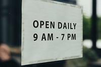 Shop open hours signboard on a window