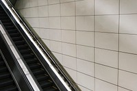 Escalator with blank tiled wall