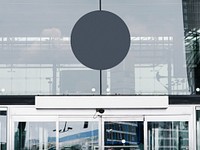 Gray circular signboard mockup in front of a building
