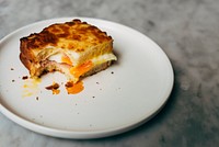 Bitten egg sandwich on a plate