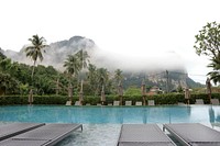 View of a misty mountain from a hotel pool