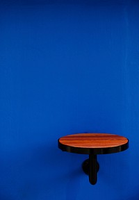 Round wooden table attached to a wall