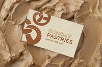 Pastries business card mockup psd on brown frosting texture