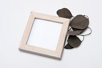 Wooden picture frame mockup psd with aesthetic dried leaf