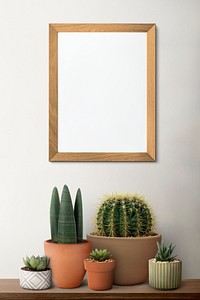 Blank wooden picture frame on a shelf with cactus